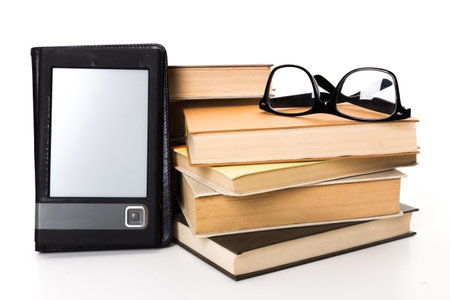 E-reader and books arranged with stylish glasses on a neutral background