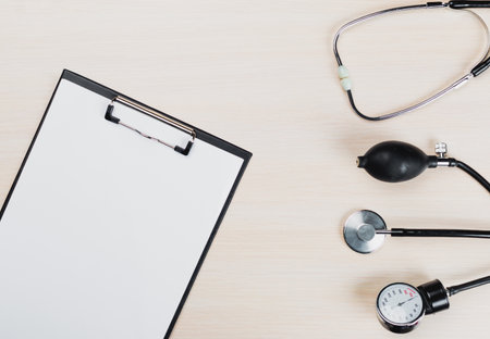 Doctors tools and blank clipboard on wooden surface in medical setting