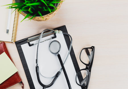 Medical tools on a desk with a plant and stationary in a professional settingの写真素材