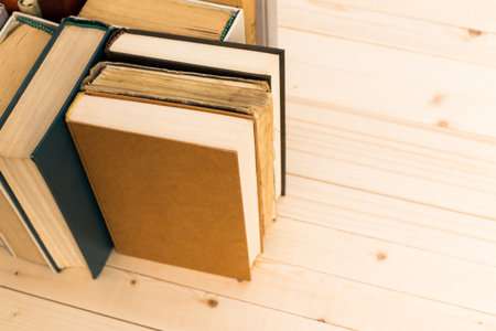 Books arranged on a wooden shelf in a cozy reading nook during the afternoon