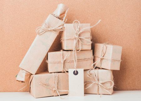 Gift wrapped packages stacked on a table against a brown background during daylight