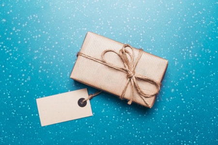 Beautifully wrapped gift box on a blue background with sparkling details