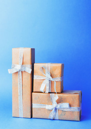 Beautifully wrapped gifts stacked against a bright blue background ready for celebration