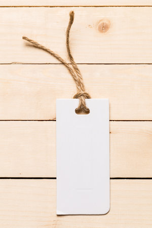 Blank tag on wooden surface ready for labeling or decoration project