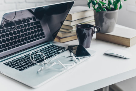 Working at a desk with technology and plants in a bright and organized workspace