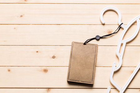 Minimalist setting with a notebook and a white hanger on a wooden surfaceの写真素材