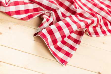 Red and white checkered tablecloth gracefully draping over wooden surface