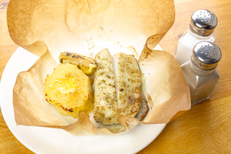 Delicious grilled fish with pineapple served on a plate at a casual dining settingの写真素材