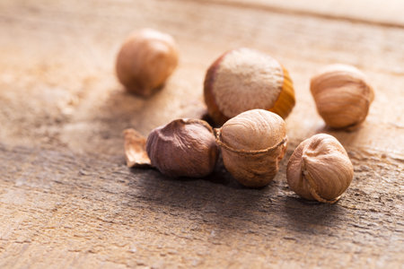 Dried hazelnuts resting on a wooden surface in natural light during afternoon