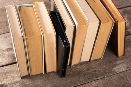 Collection of books and a wallet arranged on a rustic wooden surface