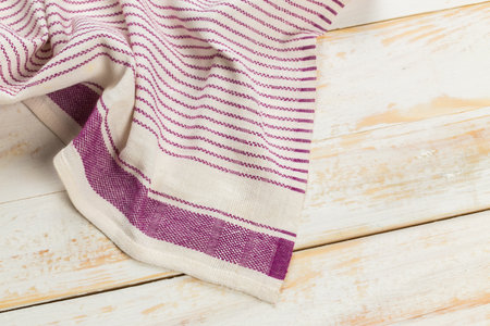 Textile fabric with purple stripes placed on a wooden surface for textile design displayの写真素材