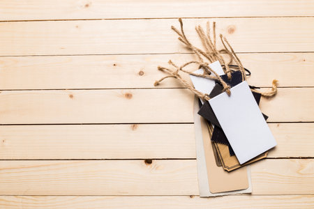 Blank and decorative tags arranged on a wooden surface for crafting projectsの写真素材