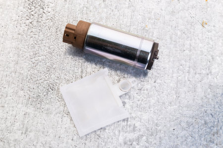 Detailed view of a fuel pump assembly on a gray surface showcasing mechanical componentsの写真素材