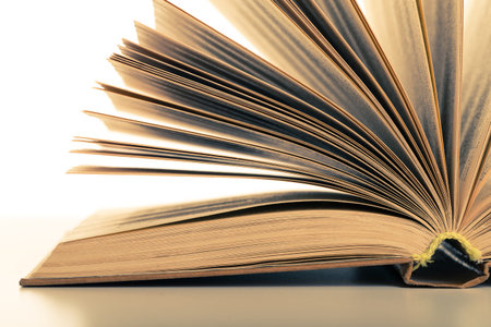 Open book with pages flipping in soft light creates serene reading atmosphere