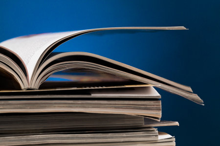 Stacks of opened books on a blue background highlighting their pages and details