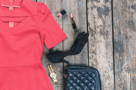 Fashion essentials displayed on rustic wooden background featuring a dress, accessories, and makeupの写真素材