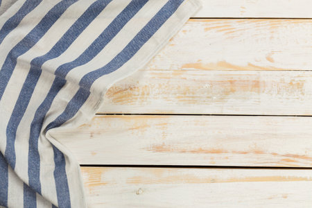 Striped fabric draped over wooden surface in natural light settingの写真素材