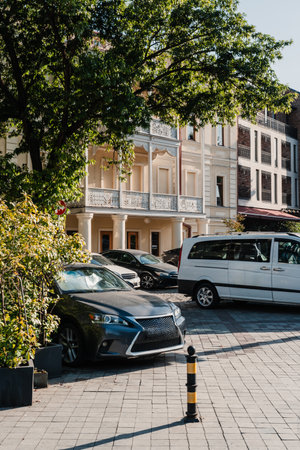 Parked vehicles near a historic building in an urban environment on a sunny dayの写真素材