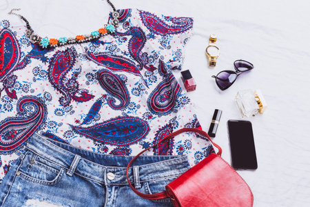 Fashion accessories and clothing arranged on a flat surface during daytime