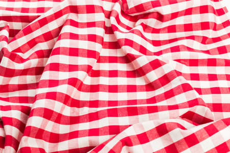 Red and white gingham fabric draped on a surface for picnic or table setting