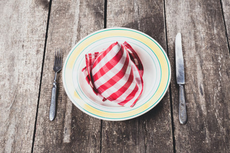 Table setting with checkered napkin on wooden surface for a meal gathering