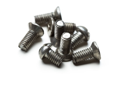 Various silver screws arranged on a white background for close-up inspection