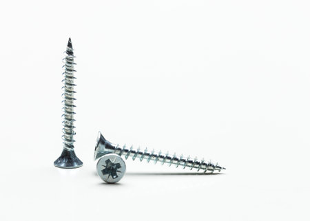 Screws arranged on a white surface showcasing various angles and details in bright lighting