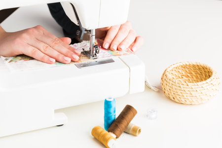 Sewing fabric with colorful threads at a crafting table in a bright workspace