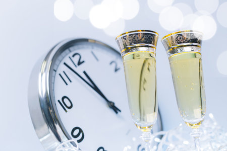 Countdown celebration with champagne glasses and clock welcoming the new yearの写真素材
