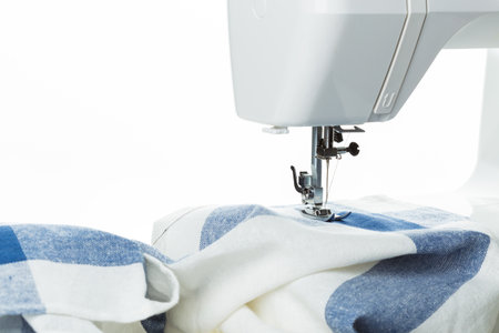 Sewing machine working on blue and white fabric during a crafting session