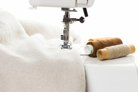 Crafting a fabric project with a sewing machine and spools of thread in a bright workspace