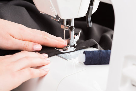 Sewing machine in action with hands guiding fabric during a creative crafting session