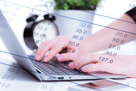 Data analysis with laptop and clock during work hours in an office setting