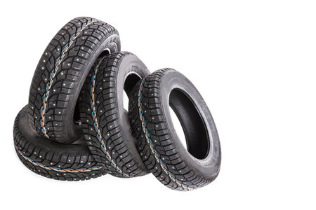 New winter tires stacked together on a clean white background for vehicle enhancement