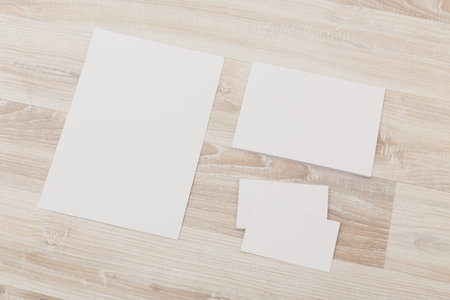 White paper sheets arranged on a light wooden surface for crafting purposes