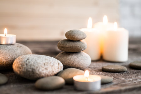 Serenity of stacked stones and candles creating a calming atmosphere in a cozy settingの写真素材
