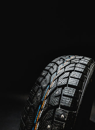 Winter tire with traction features displayed against a dark backgroundの写真素材