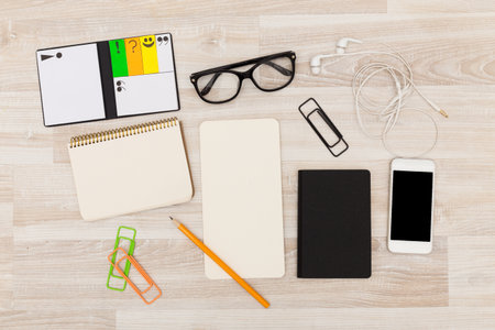 Creative workspace with stationery items and technology on wooden table
