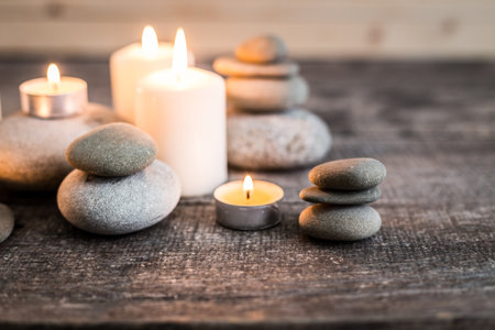 Calming arrangement of candles and stones on rustic wooden surface in serene setting