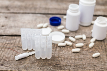 Medical supplies and medications arranged on a wooden surface in clinical setting
