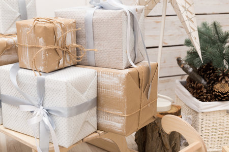 Holiday presents stacked on a wooden surface in a cozy indoor setting