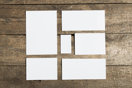 Collection of blank paper cards arranged on rustic wooden table for creative projects