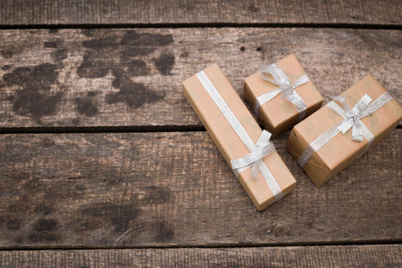 Rustic wooden table with three wrapped gift boxes ready for celebration or event