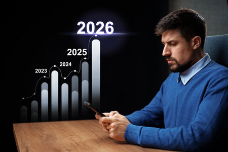 Man analyzing growth charts on smartphone with projections through 2026の写真素材