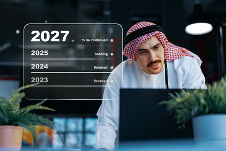 Man in traditional attire working on laptop with progress timeline displayed for upcoming years