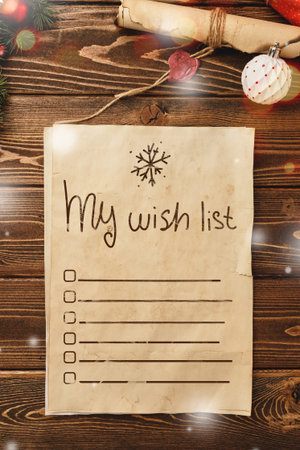 Creative wish list on aged paper with festive decorations on rustic wooden tableの写真素材