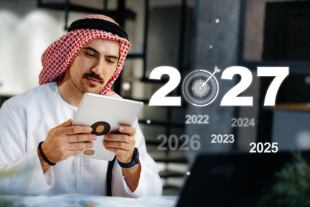 Focused businessman plans goals for the upcoming year while using a tabletの写真素材