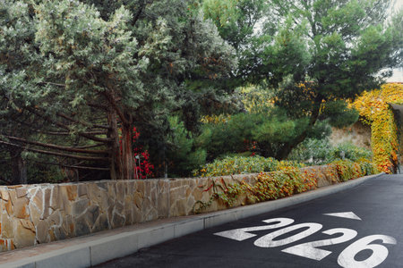 Scenic road with 2026 marking surrounded by lush greenery and colorful foliage