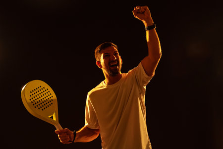 Celebration of victory in a sports match with a paddle in hand during evening practice