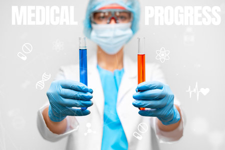 Researcher in lab coat holds colored test tubes representing medical progress in healthcareの写真素材